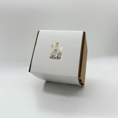 A custom box with a white belly band featuring a gold foil logo. Premium print finishing by Indigo Ross
