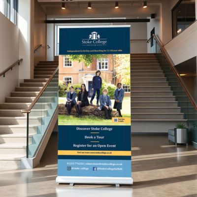 A professional pull-up banner for Stoke College, displayed in a modern reception area to promote open days and provide information to prospective families. Design and print by Indigo Ross.