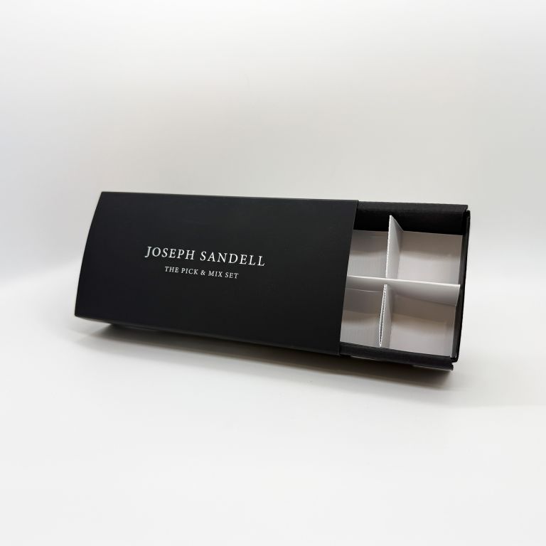A luxury 'sleeve and tray' style gift box for a Joseph Sandell set, showing the custom insert. Bespoke packaging with silver foil by Indigo Ross.