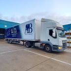 A white DAF lorry with a full vinyl wrap for A&B Glass Group, parked in an industrial yard. The design is blue and white with the company logo.