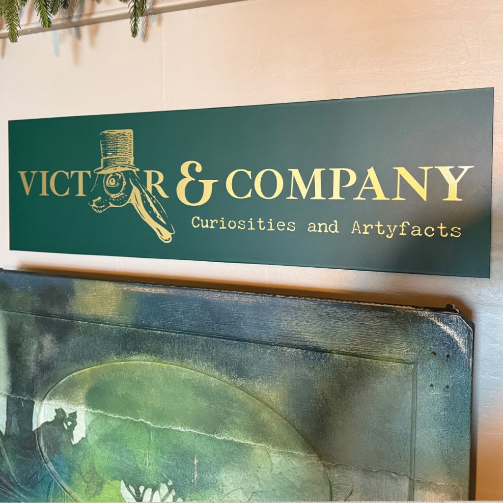 High-contrast gold and green interior signage for Victor & Company.