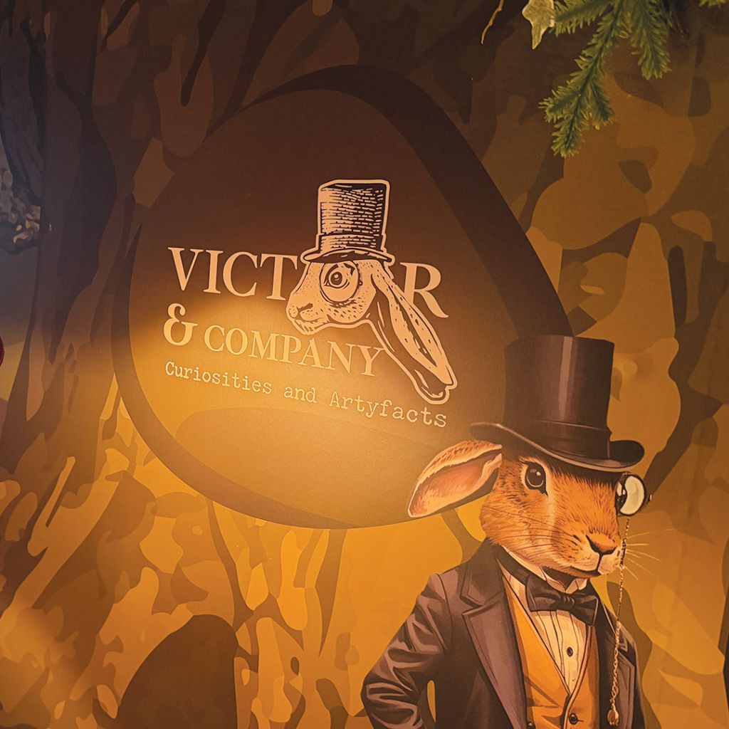 Detail shot of the Victor & Company logo integrated into the large-format wall mural.