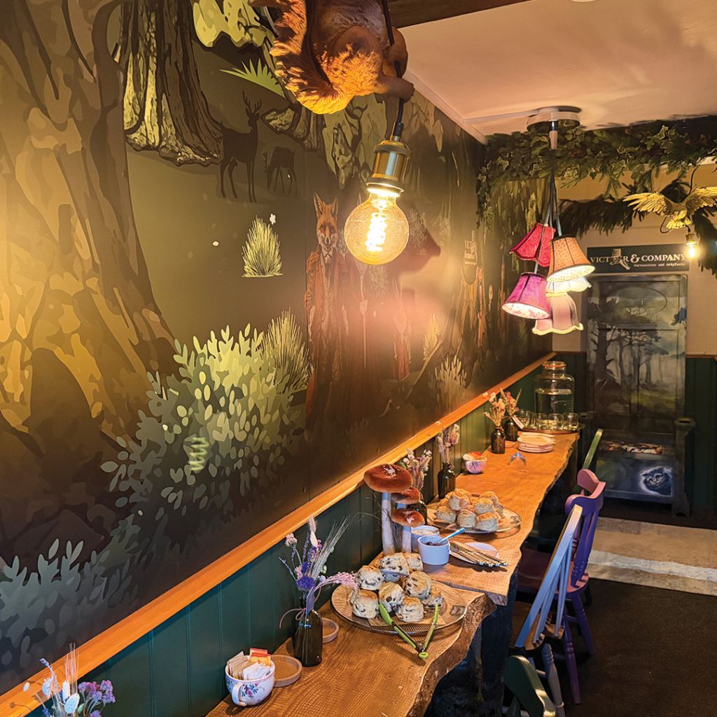Interior view of Victor & Company seating area showing the custom-printed wall mural, rustic wooden counters, and brand-aligned decor.